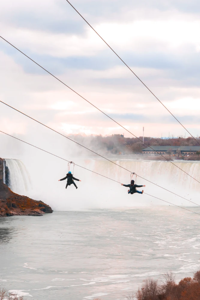 People ziplining over a lake